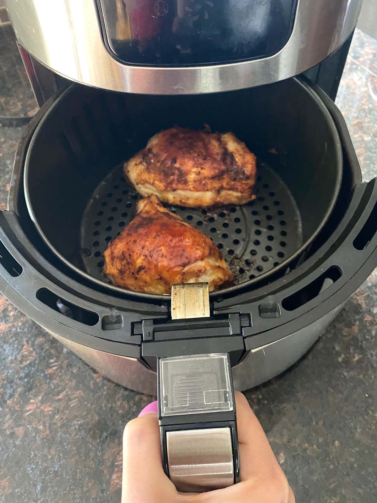 Cooked chicken thighs in an air fryer.