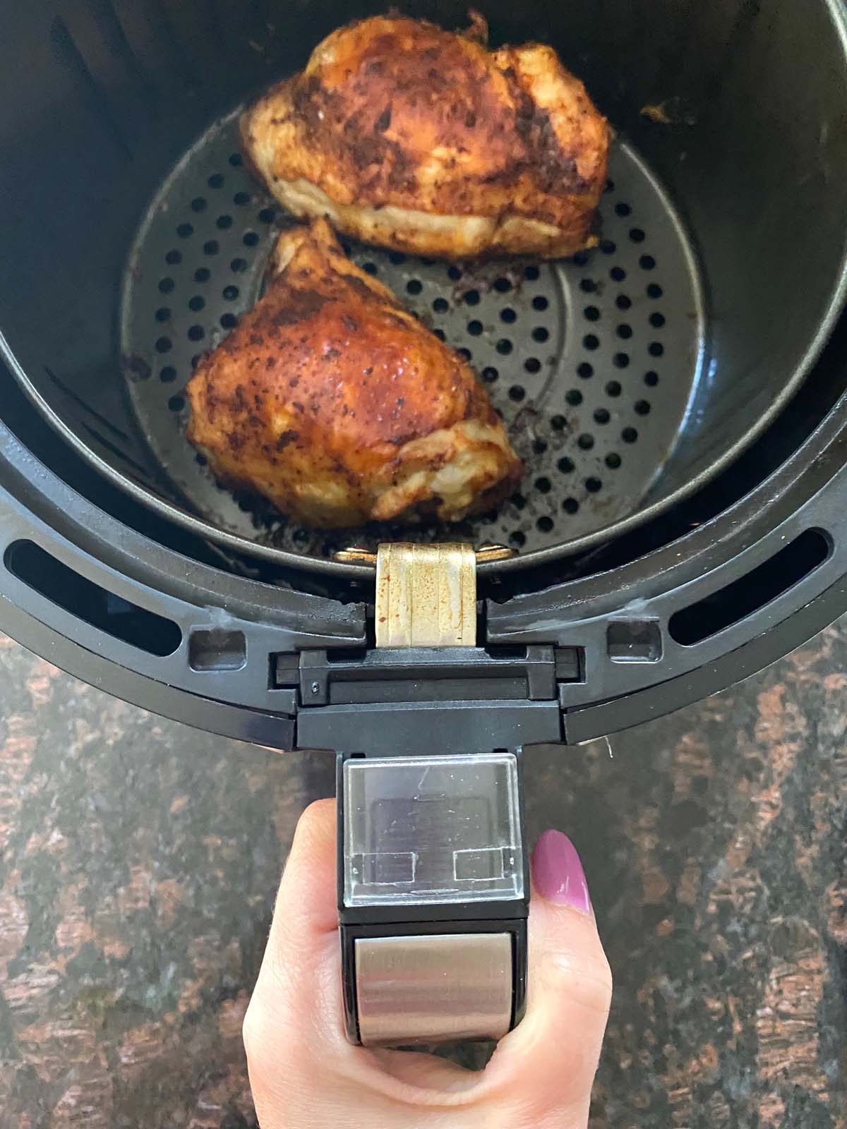 Cooked chicken thighs in an air fryer.