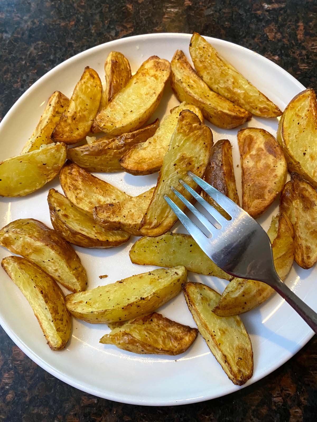 Air fried potato wedges on a plate.