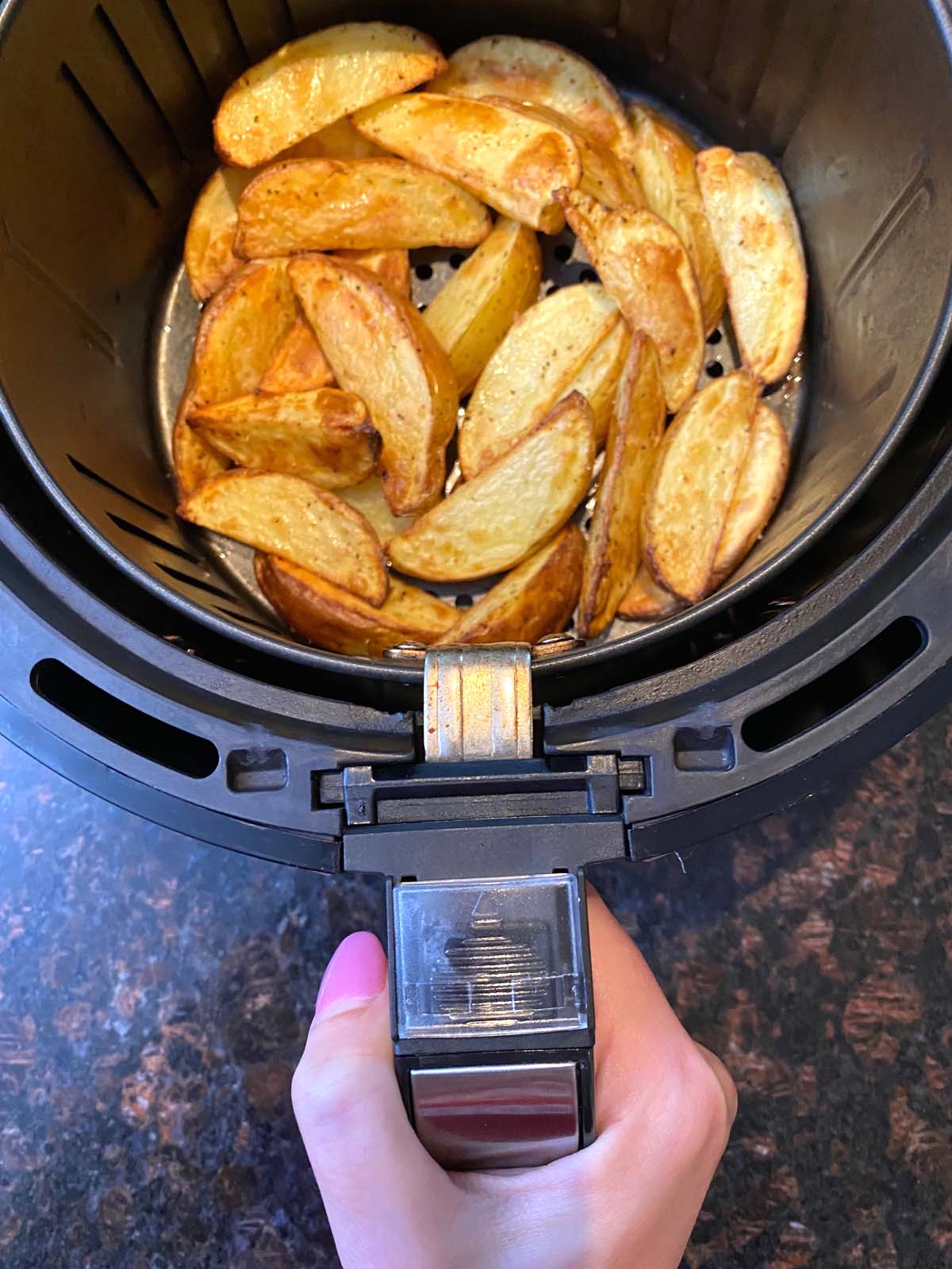 Cooked potato wedges in an air fryer.