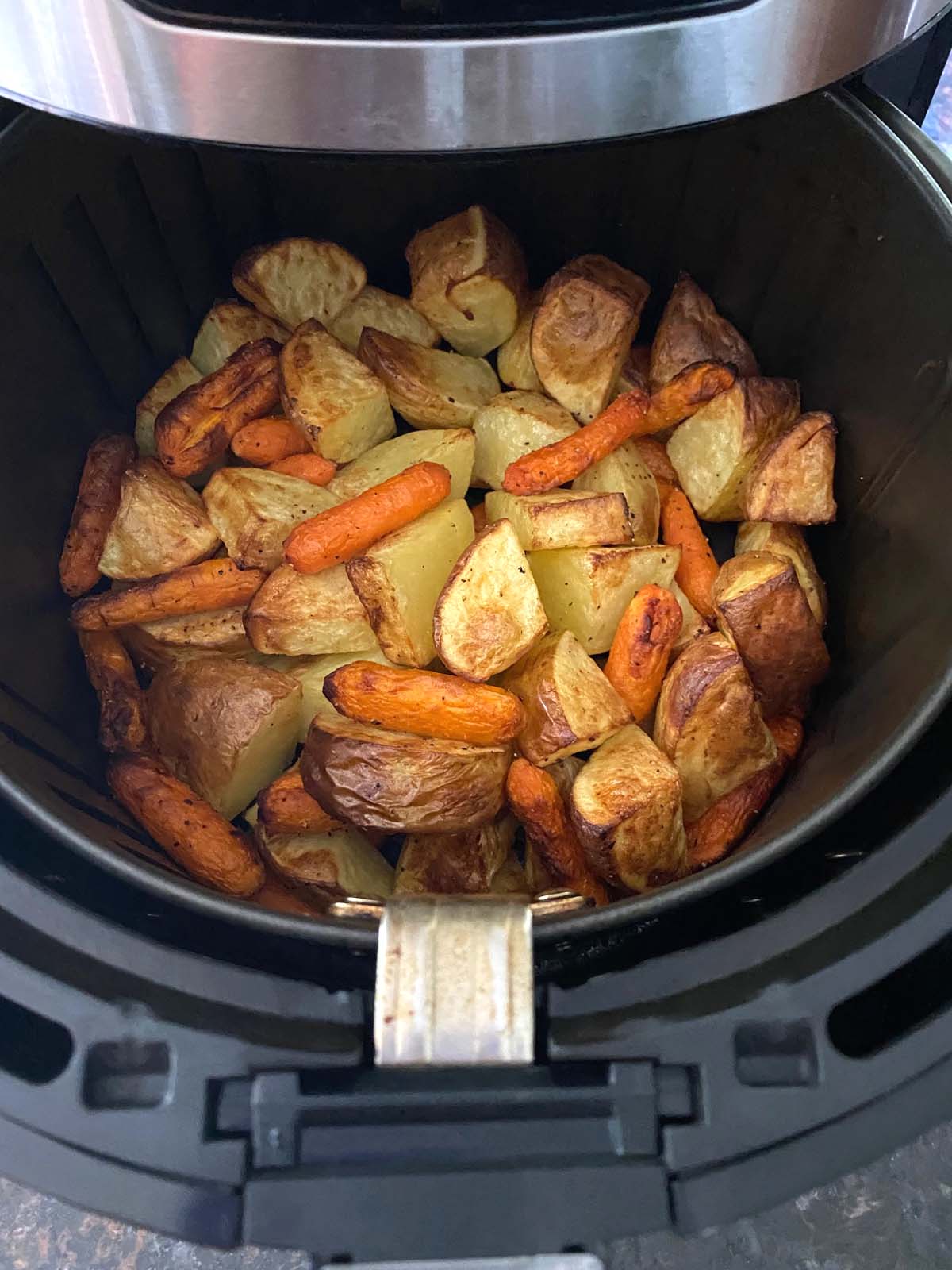 Roasted potatoes and carrots in an air fryer.