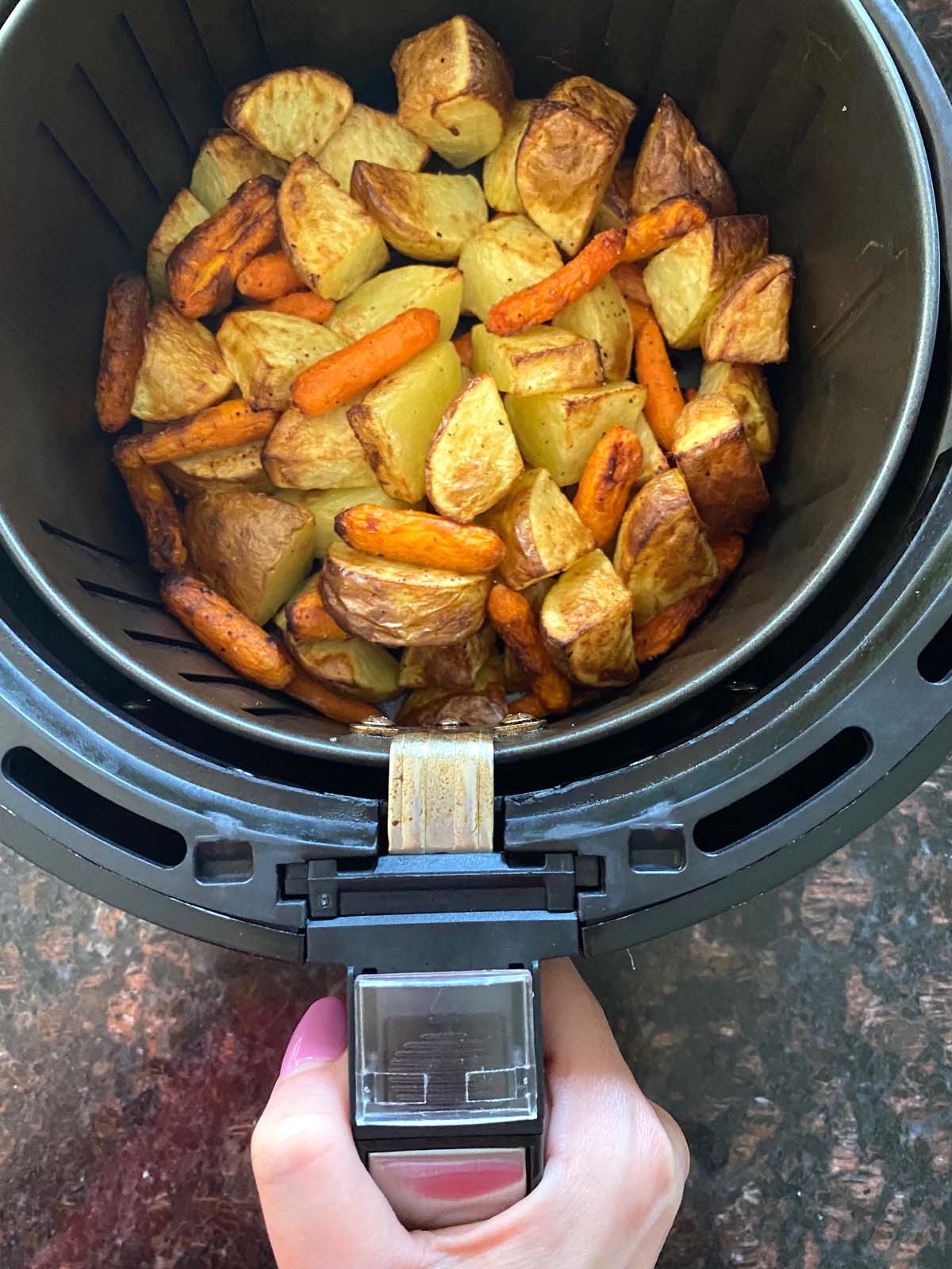 Roasted potatoes and carrots in an air fryer.