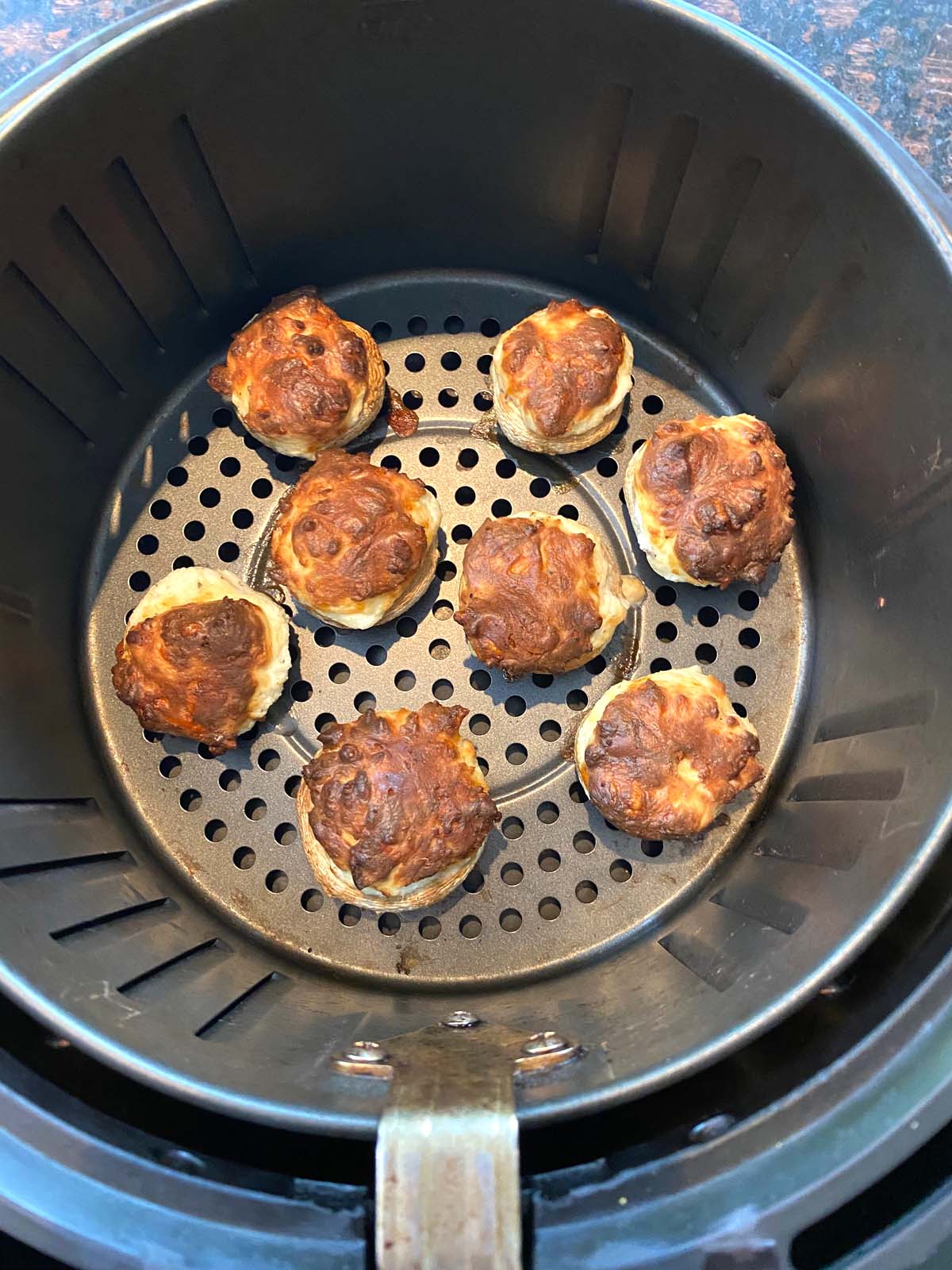 Cooked stuffed mushrooms in an air fryer. 