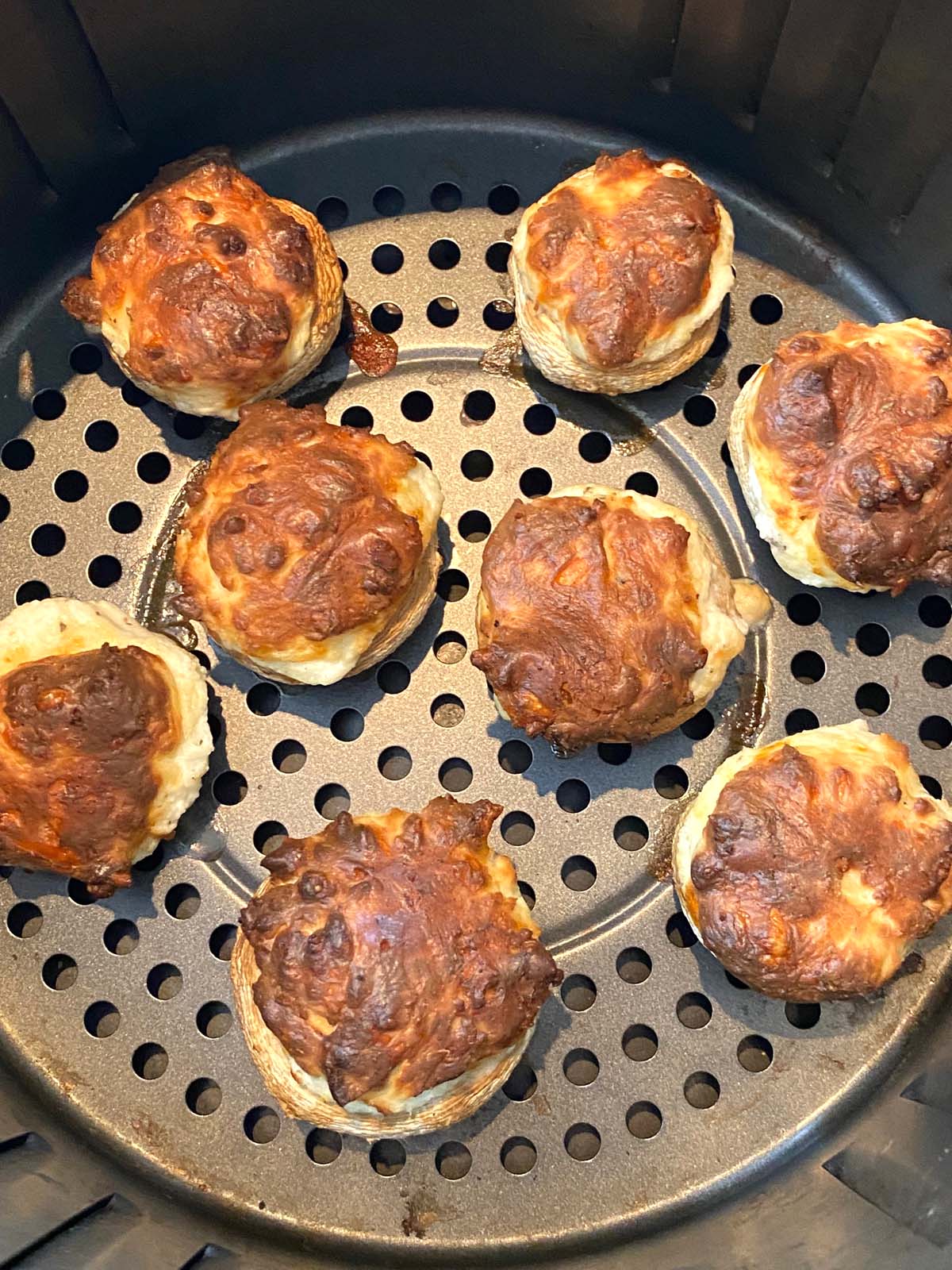 Cooked stuffed mushrooms in an air fryer. 