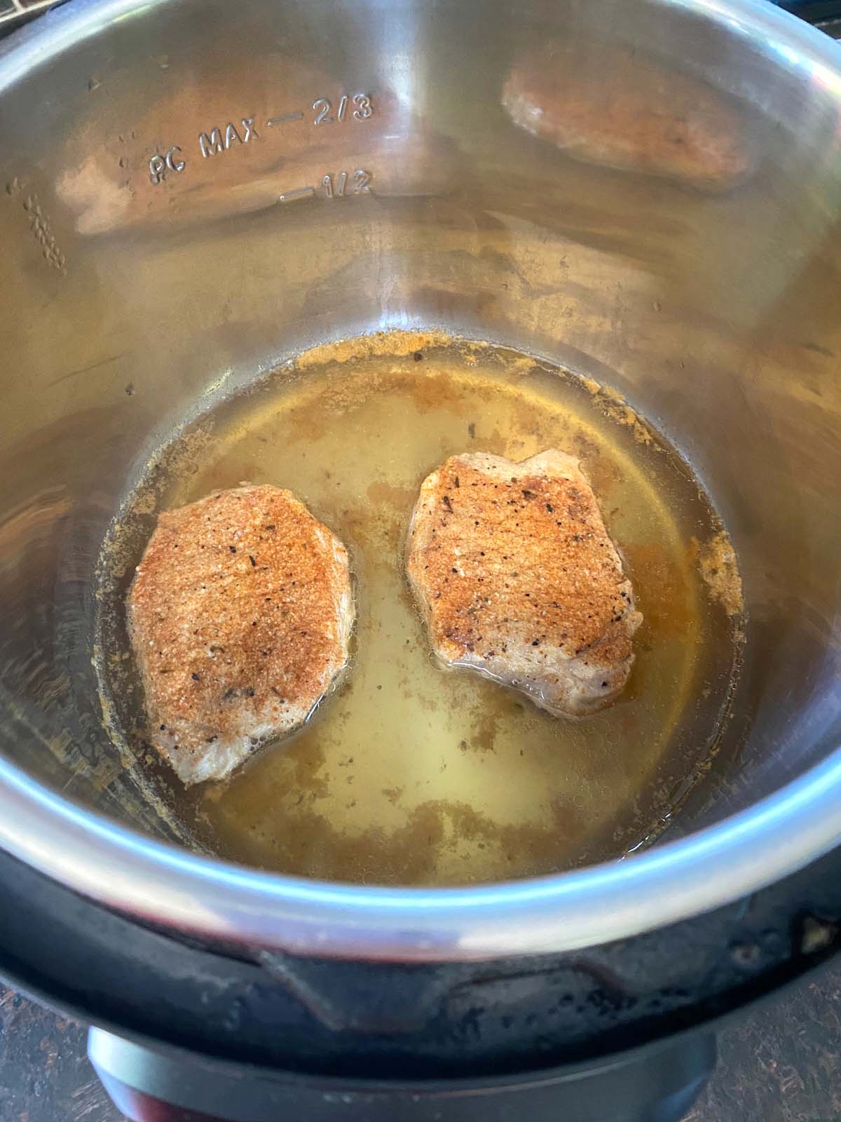Chops after cooking sitting in water in the pressure cooker with seasonings.
