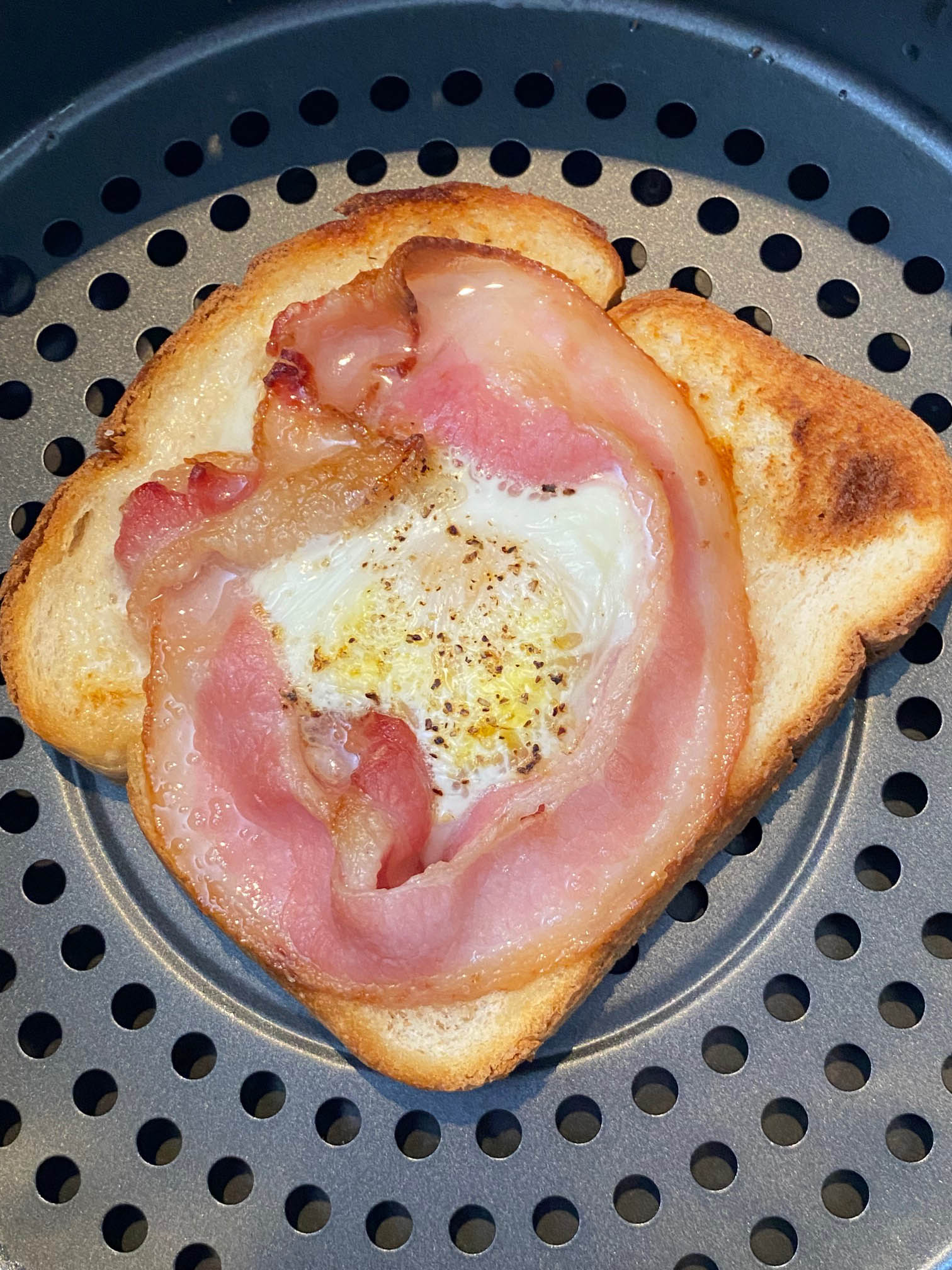 Close up of bacon egg toast recipe in air fryer basket.