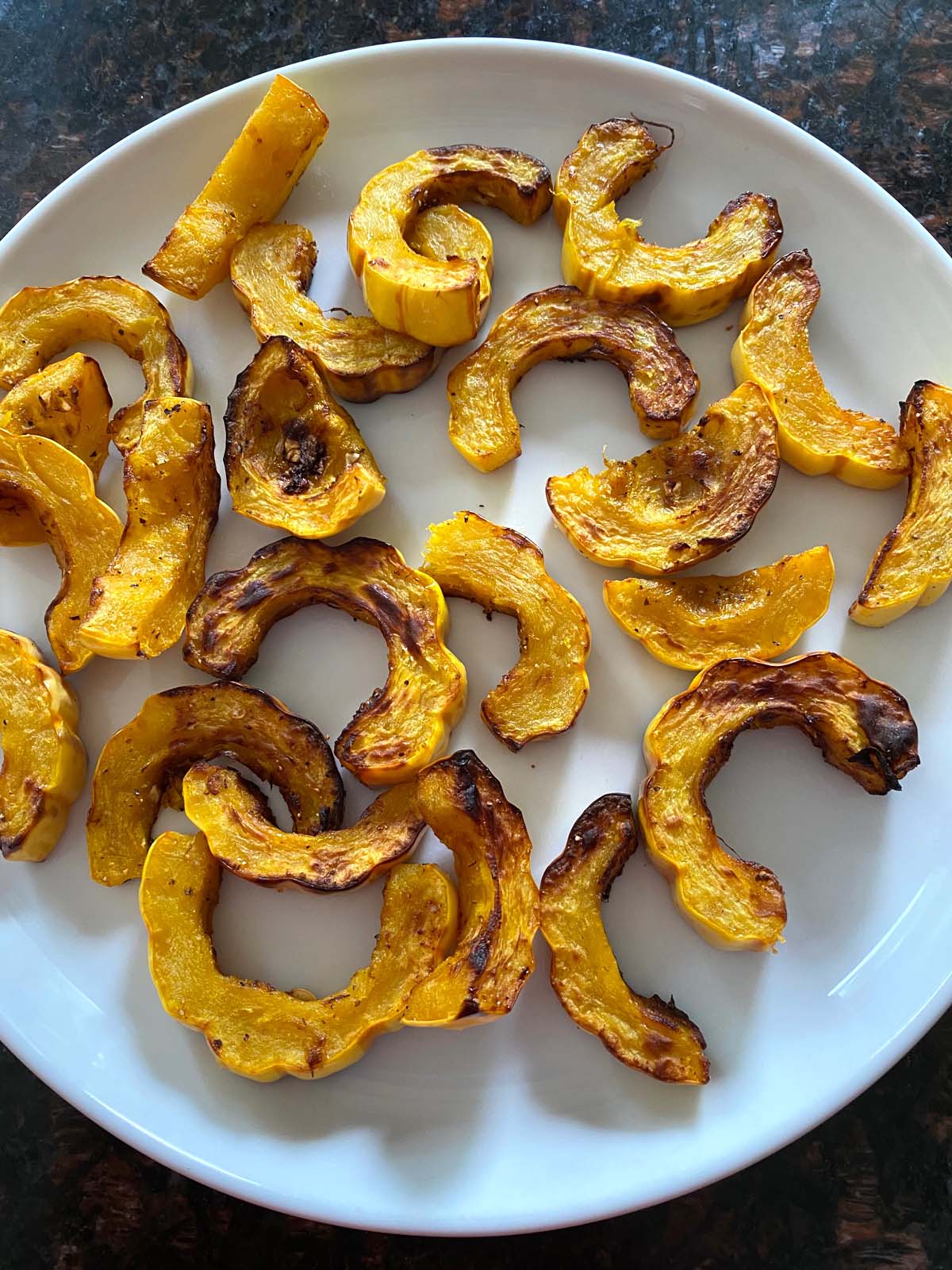 Air fried delicata squash on a white plate.