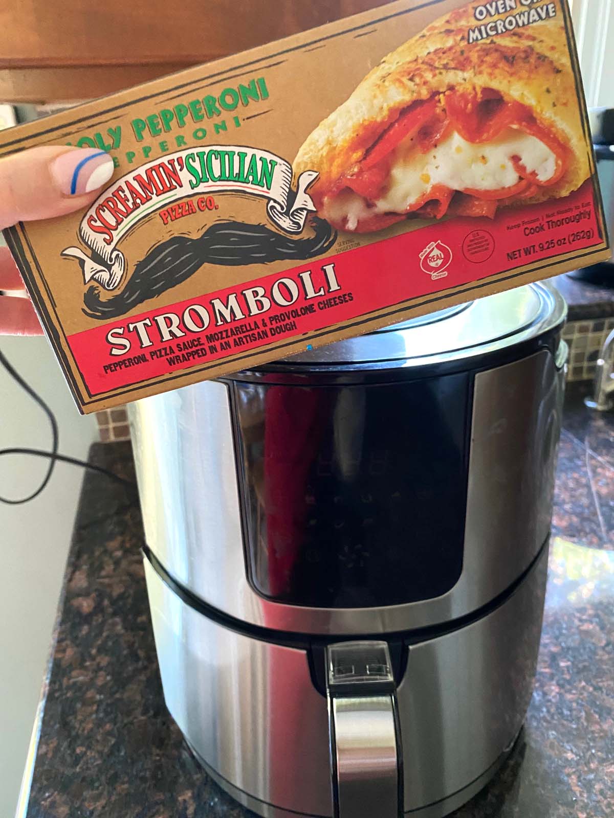 A package of stromboli being shown in front of an air fryer.