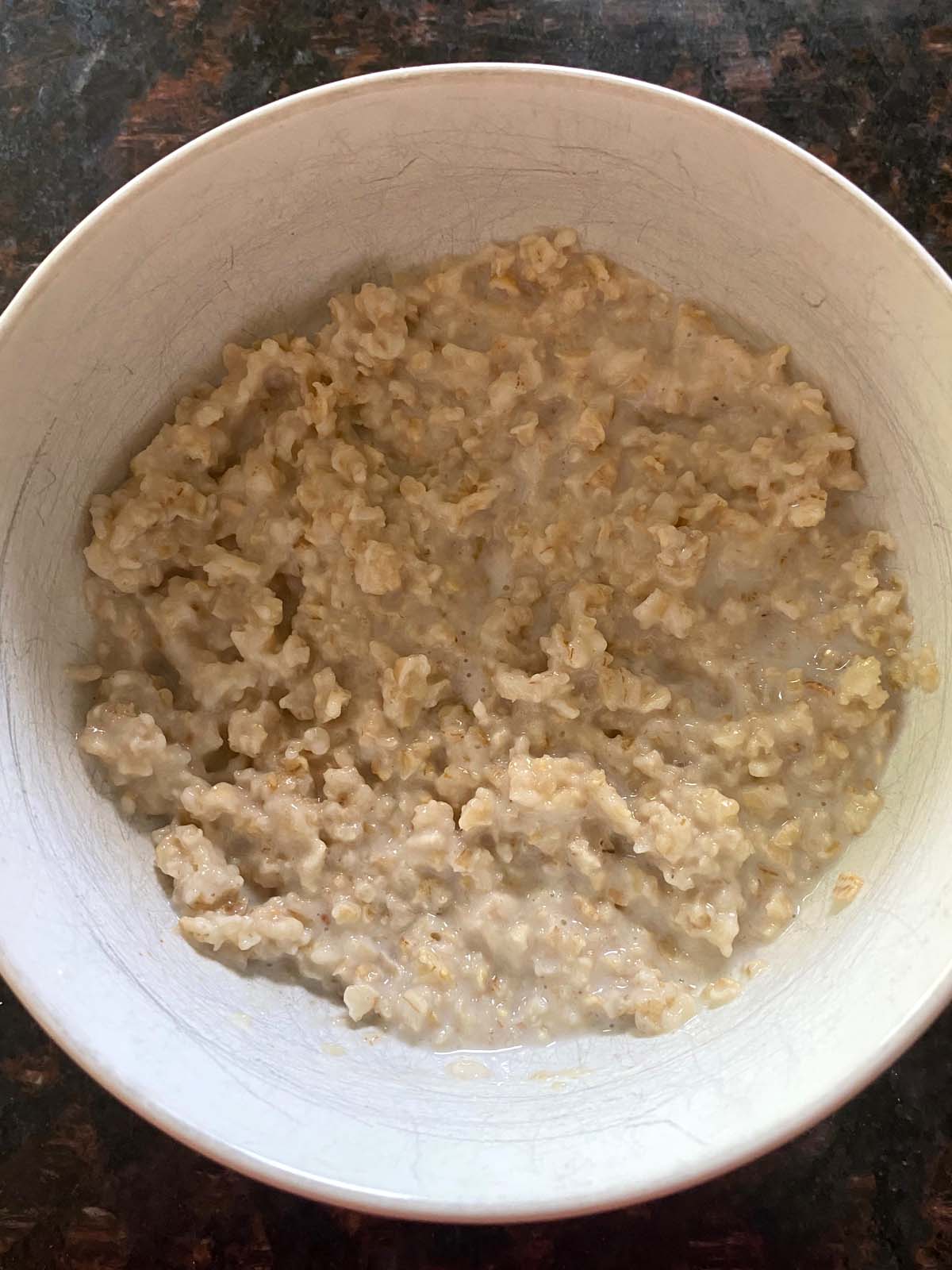 Cooked oatmeal in a white bowl.