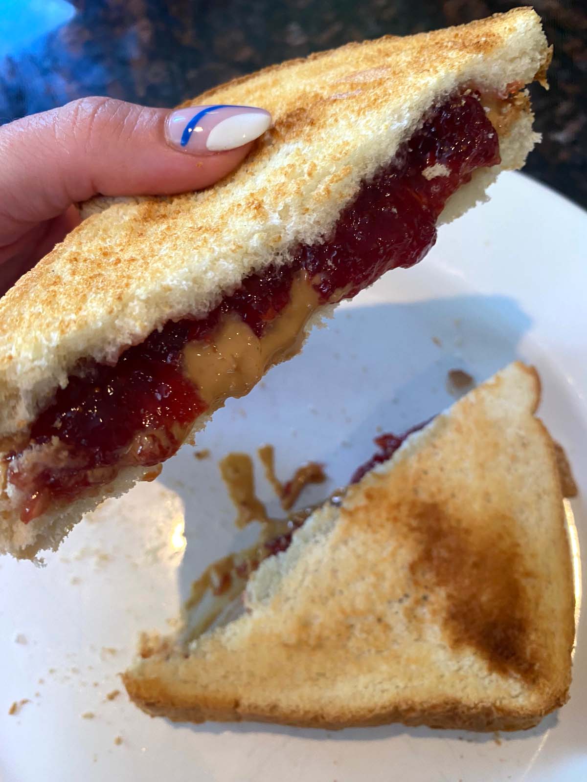 Toasted peanut butter and jelly on a white plate.
