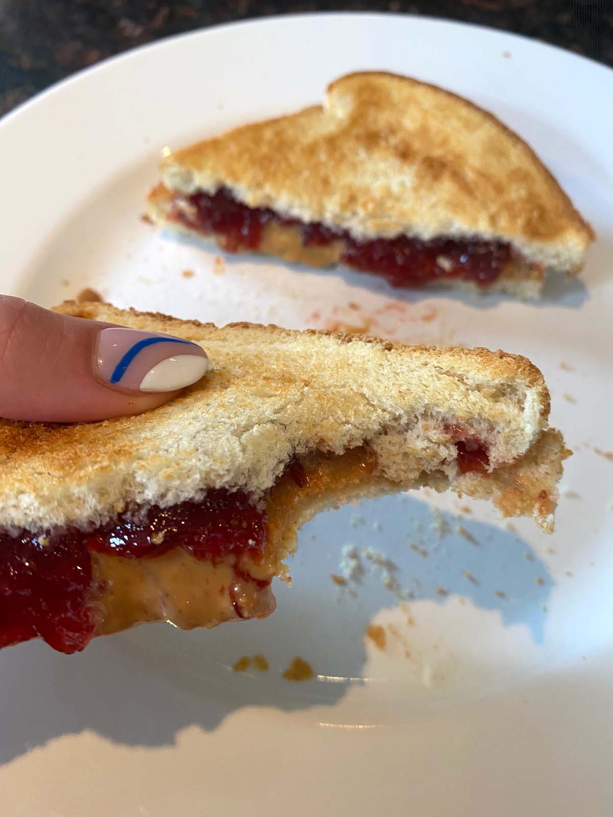 Toasted peanut butter and jelly on a white plate.