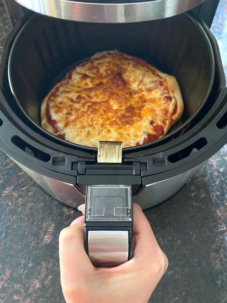 air fryer opened to show cooked pizza