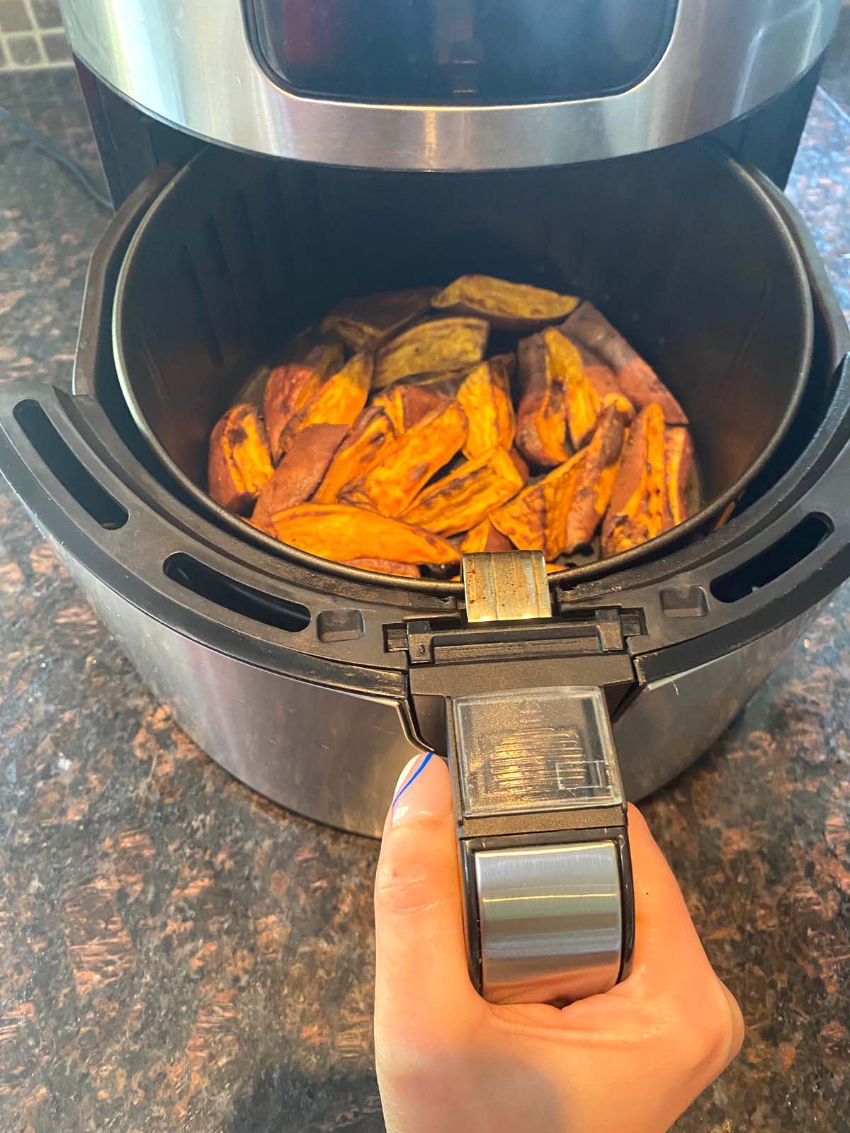 Cooked sweet potato wedges in an air fryer.