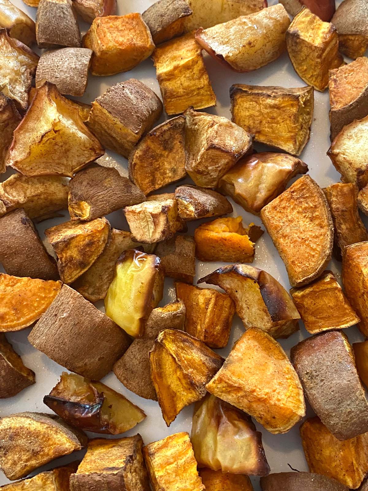 Roasted sweet potatoes and apples on a white plate. 