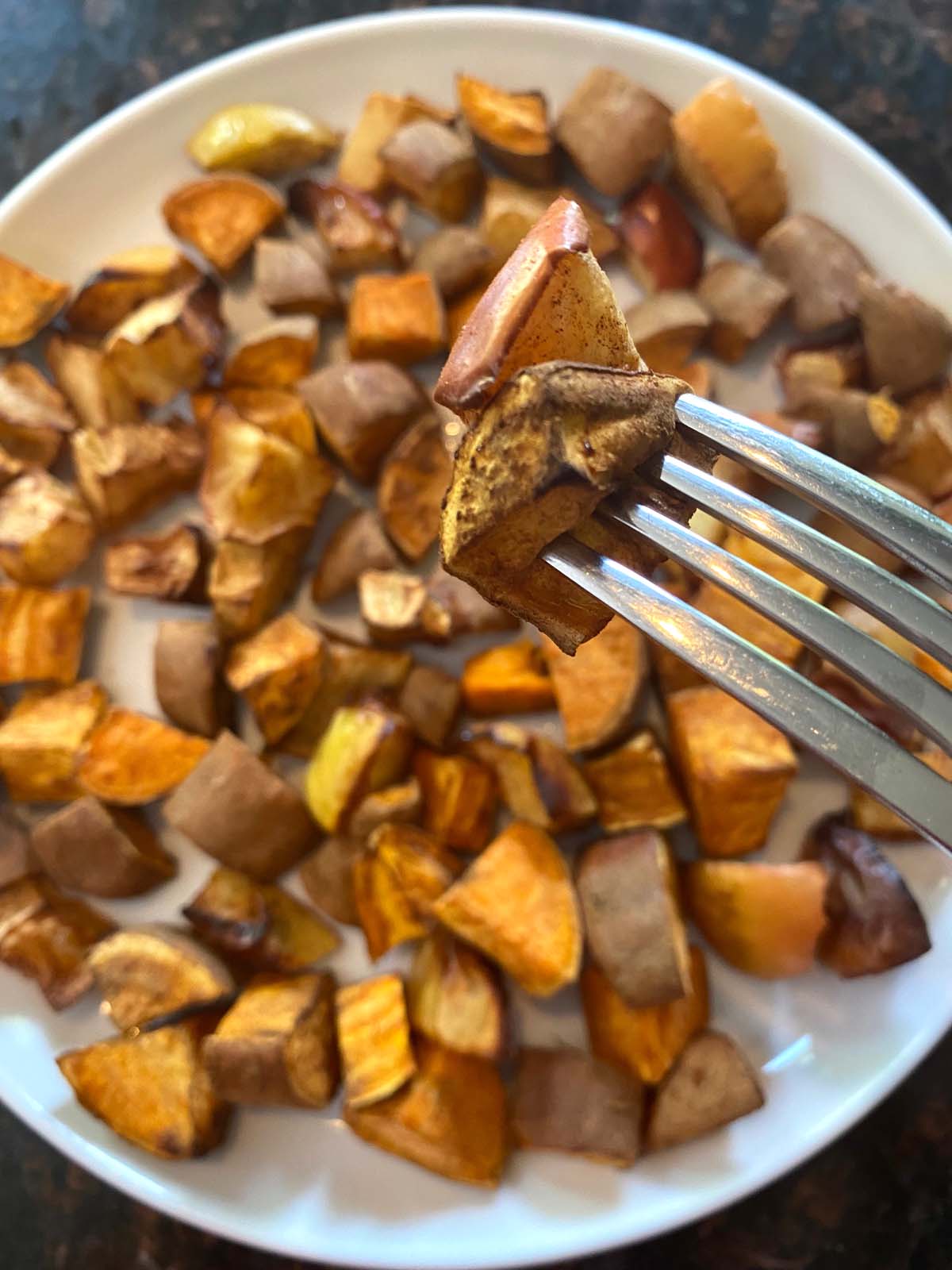 Roasted sweet potatoes and apples on a white plate. 