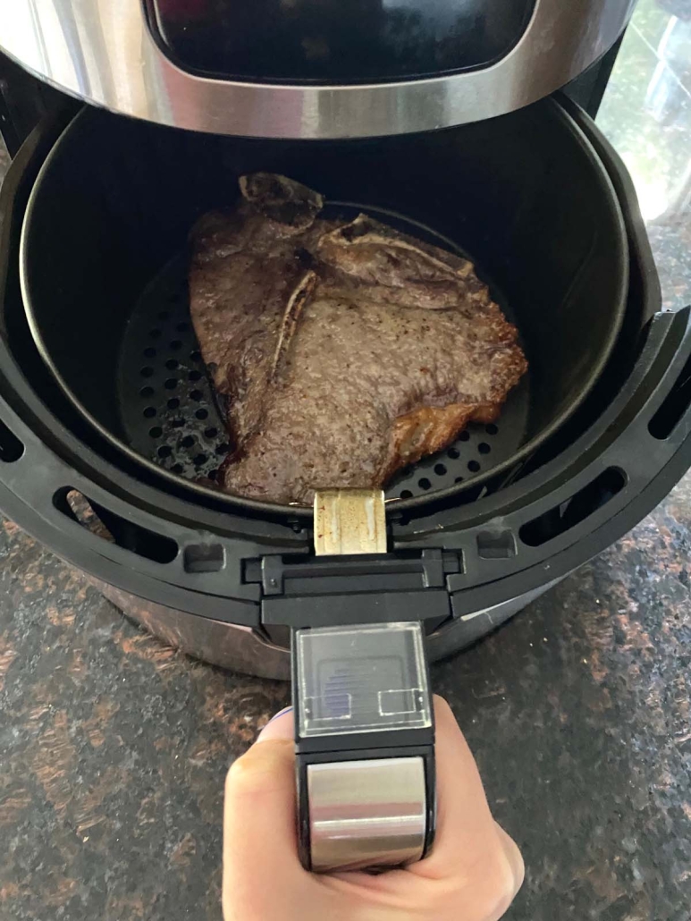 air fryer opened to show steak inside