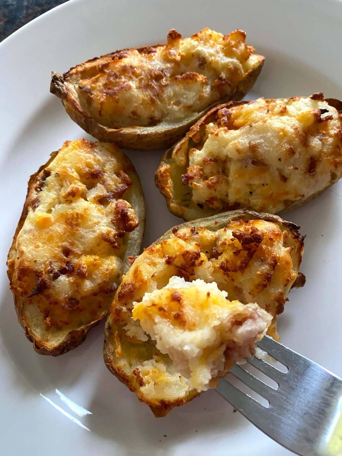 Twice baked potatoes on a white plate.