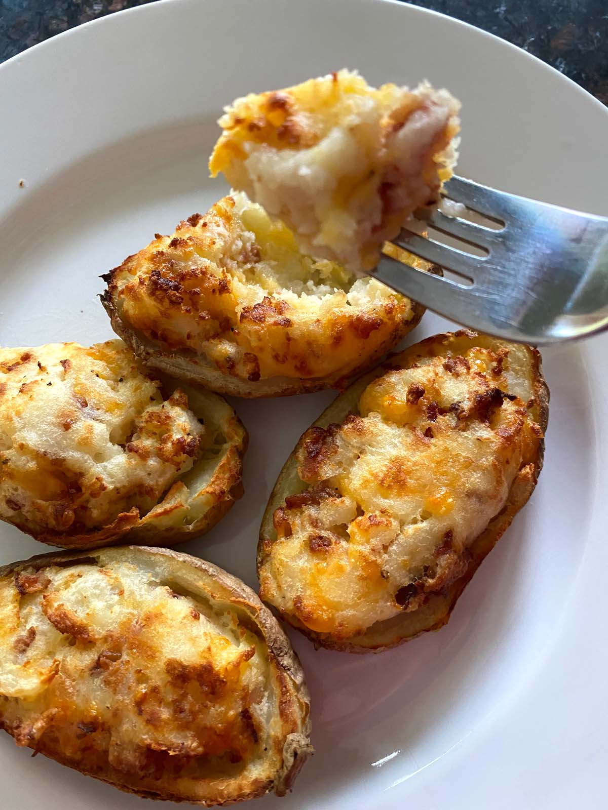 Twice baked potatoes on a white plate.