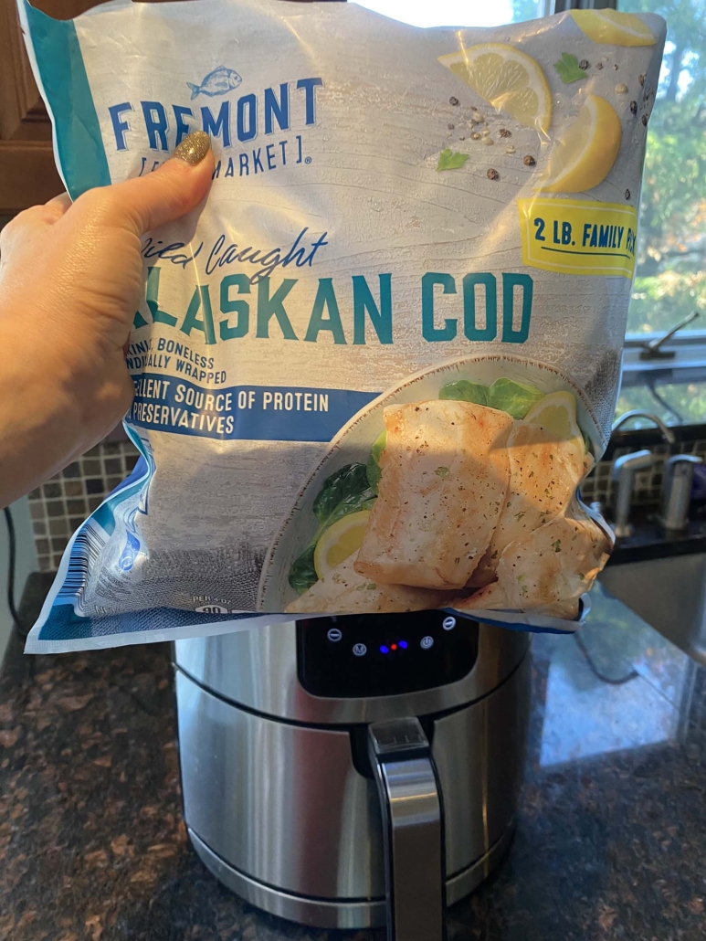 frozen cod package in front of air fryer