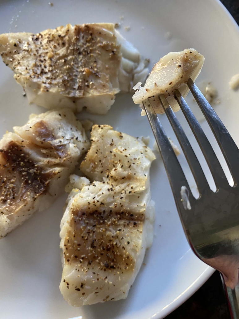 fork holding piece of cooked cod fillet