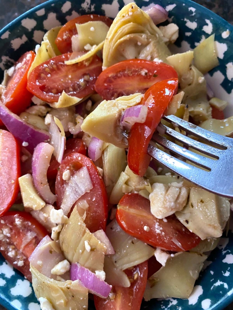 close-up of artichoke salad with tomatoes and red onion