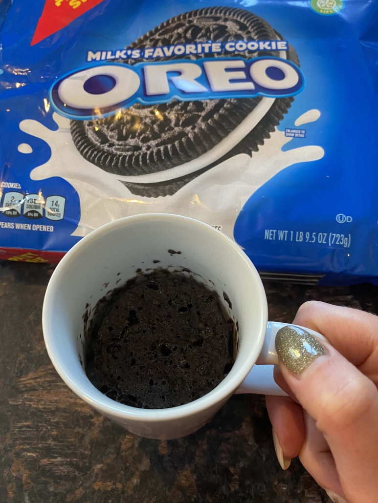 hand holding Oreo mug cake in front of package of Oreos