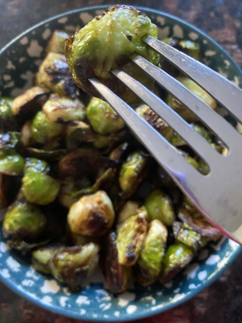 cooked and seasoned Brussels sprouts in a bowl with fork