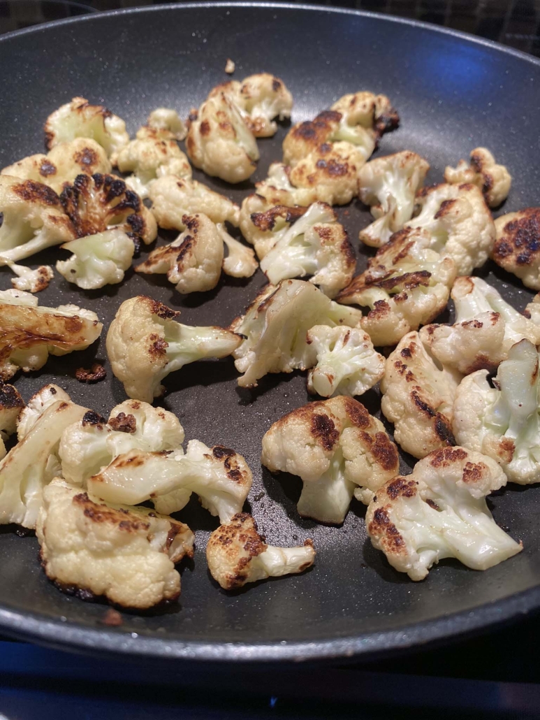 sautéed cauliflower cooking in a skillet