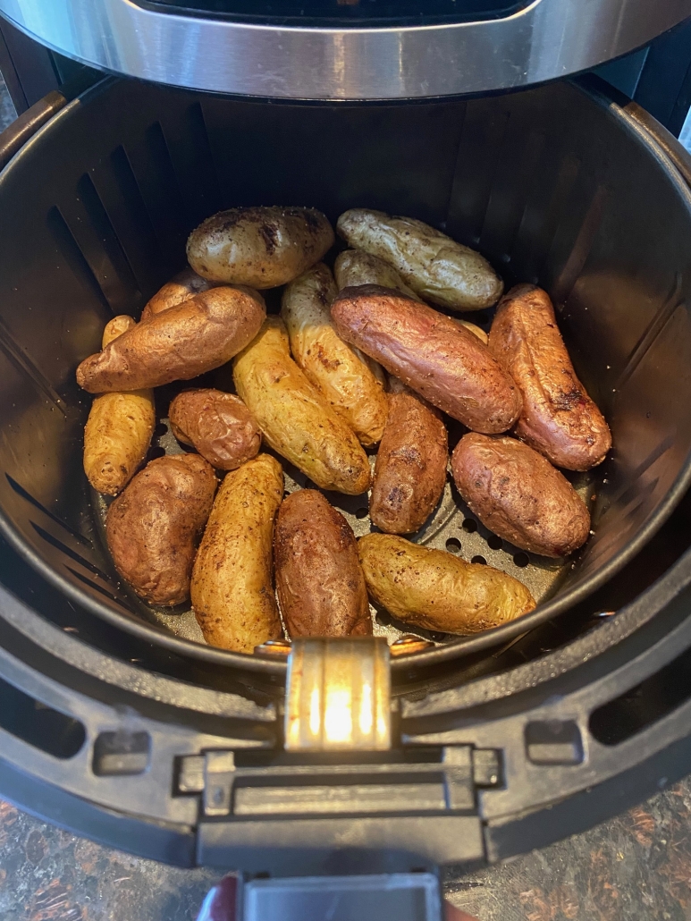 air fryer opened to show fingerling potatoes