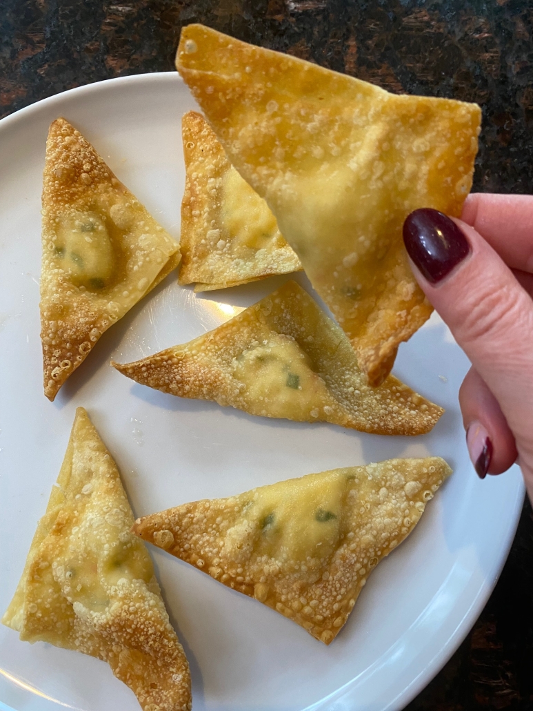 hand holding crab rangoon cooked in air fryer