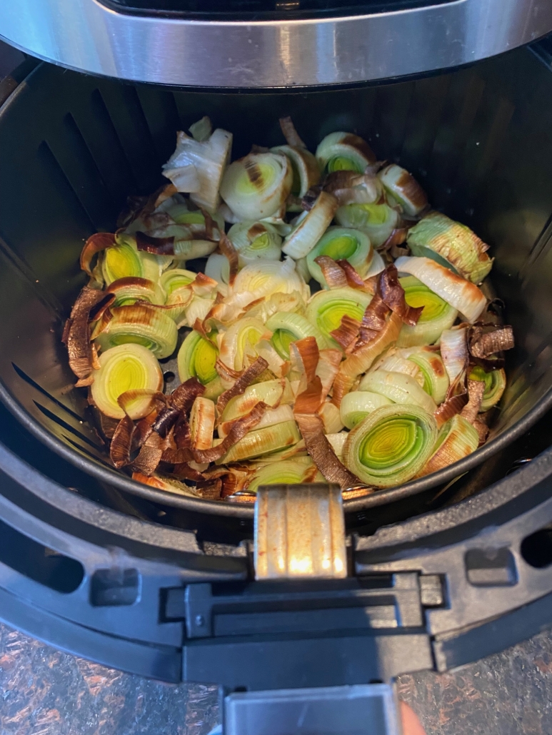 air fryer opened to show cooked leeks
