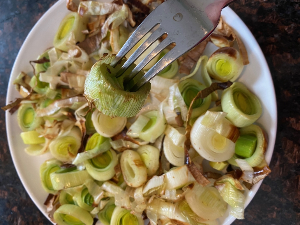 fork holding slice of cooked leek