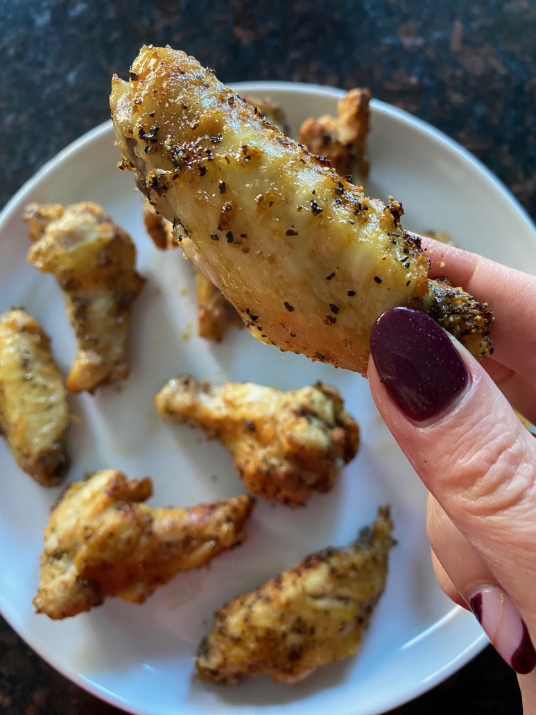 hand holding air fryer lemon pepper chicken wings