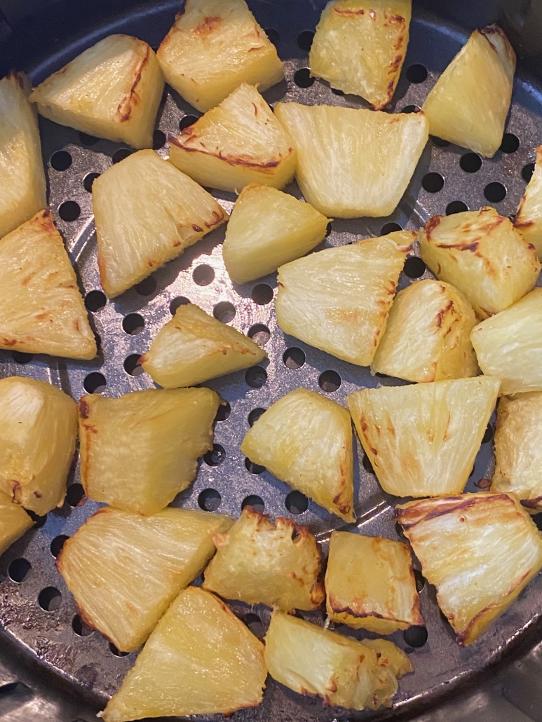 close-up of pineapple chunks in air fryer basket