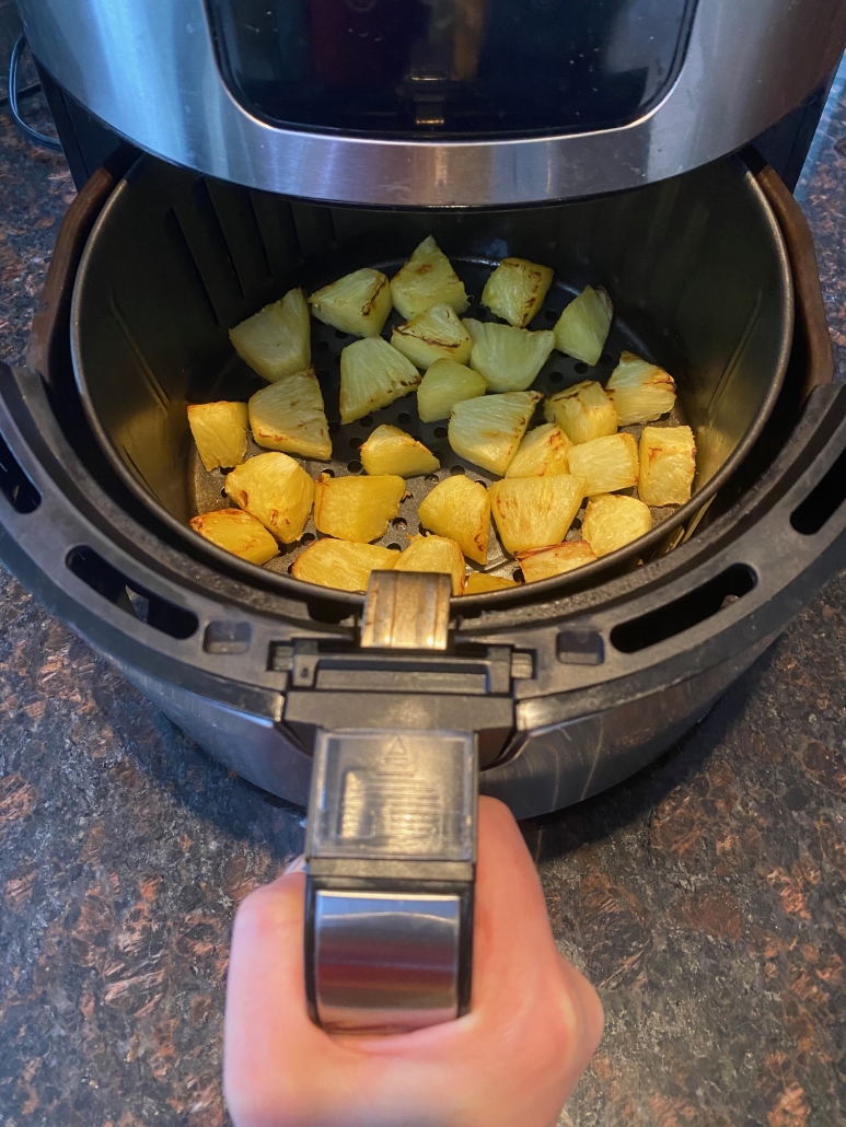 air fryer opened to show cooked pineapple
