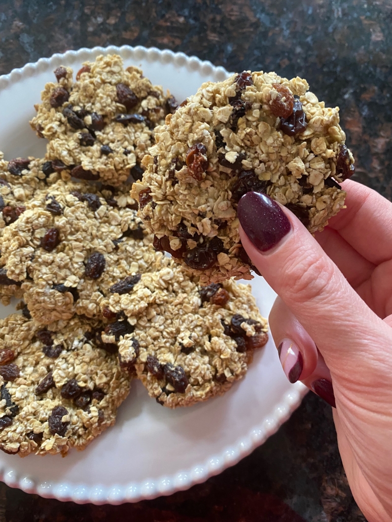 hand holding baked applesauce oatmeal raisin cookie