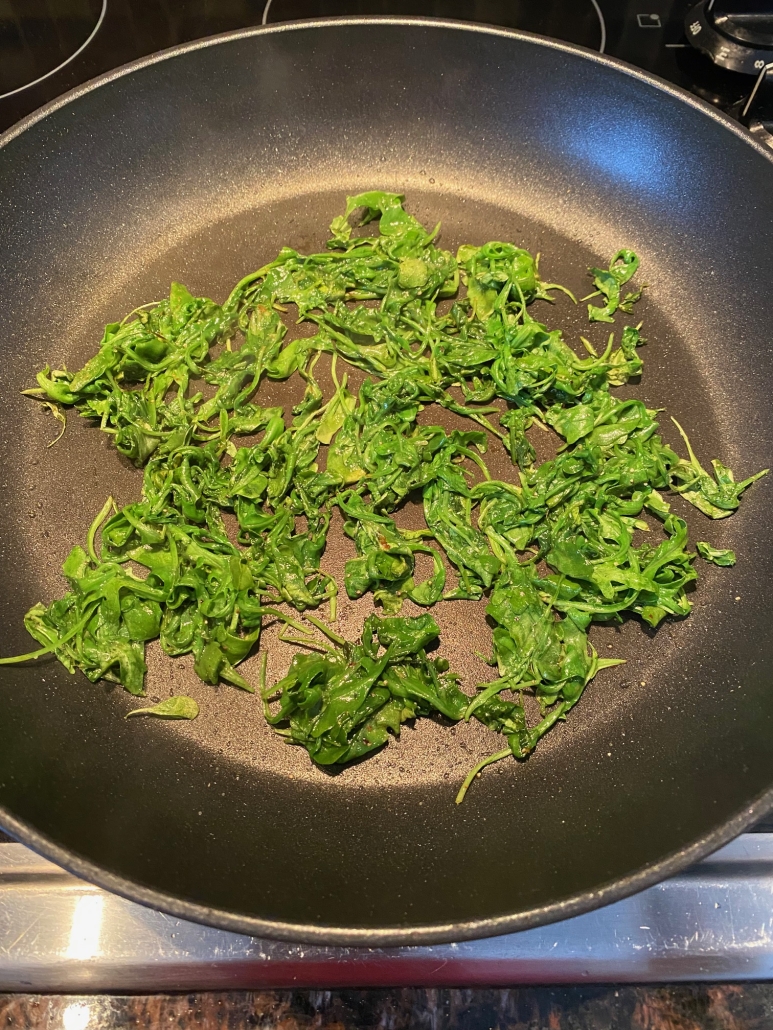 skillet of sautéed arugula