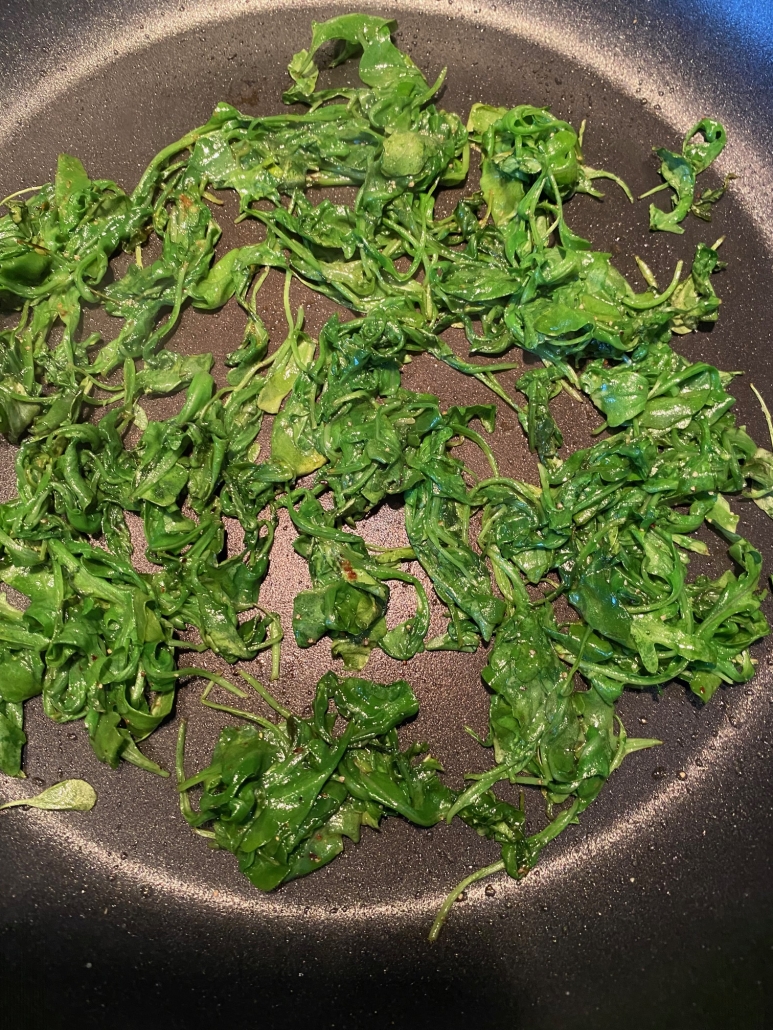 seasoned sautéed arugula in a skillet