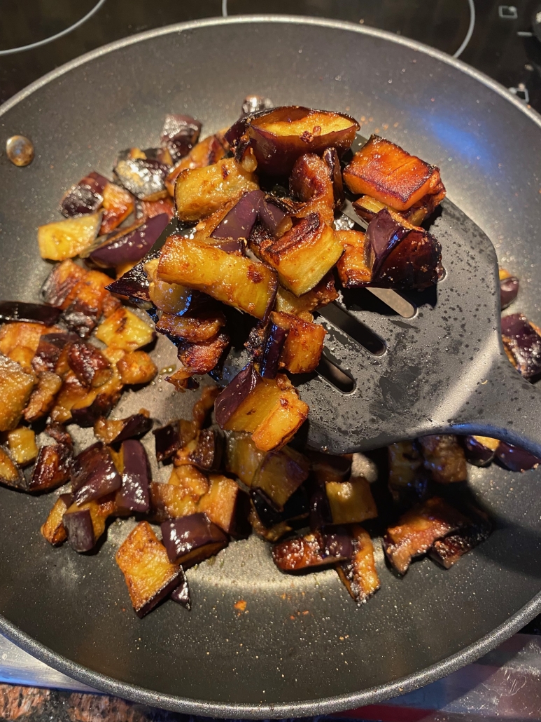 sautéed eggplant being cooked on a stovetop