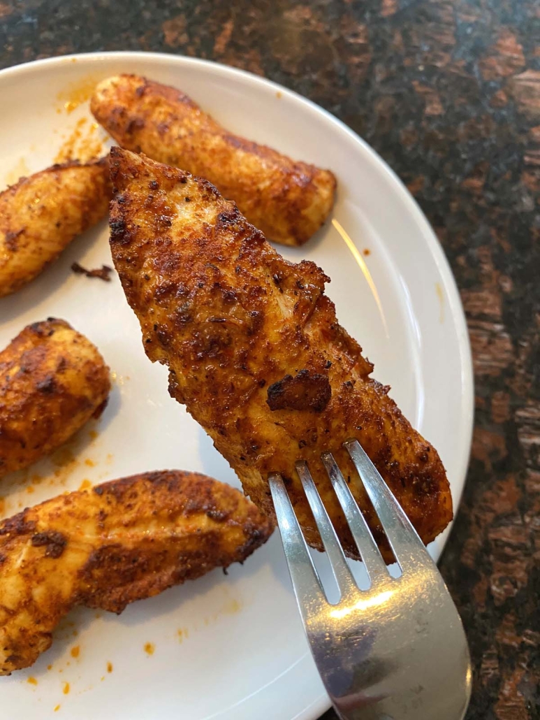 fork holding chicken tender cooked without breading