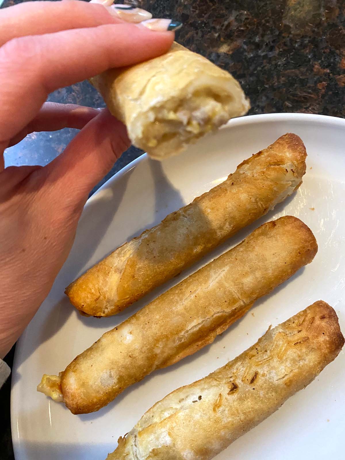 Cooked flautas on a plate.