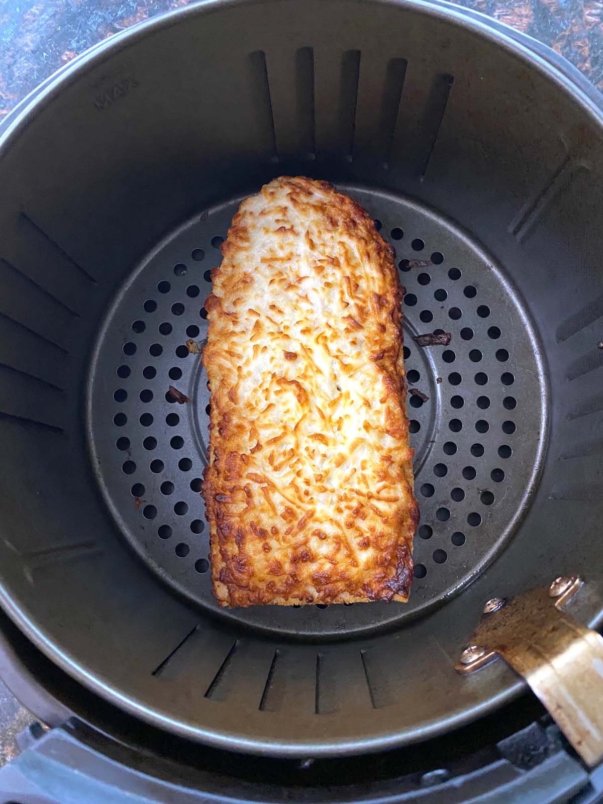 Cooked French bread pizza in an air fryer.