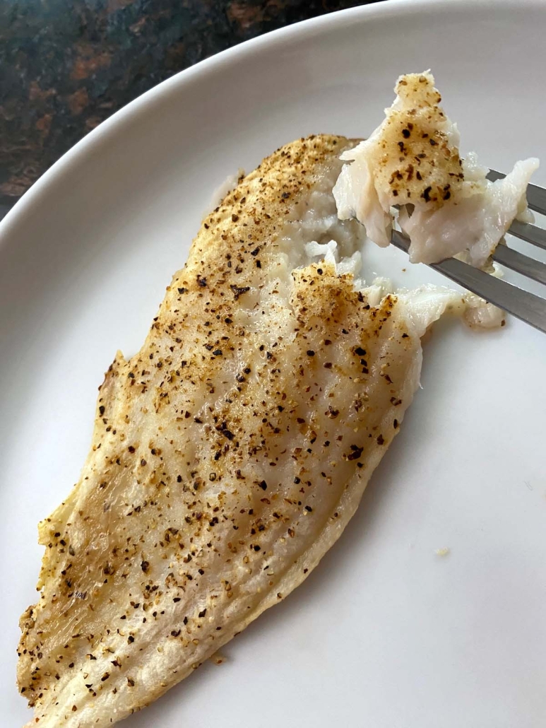 fork holding piece of air fryer cooked swai fish