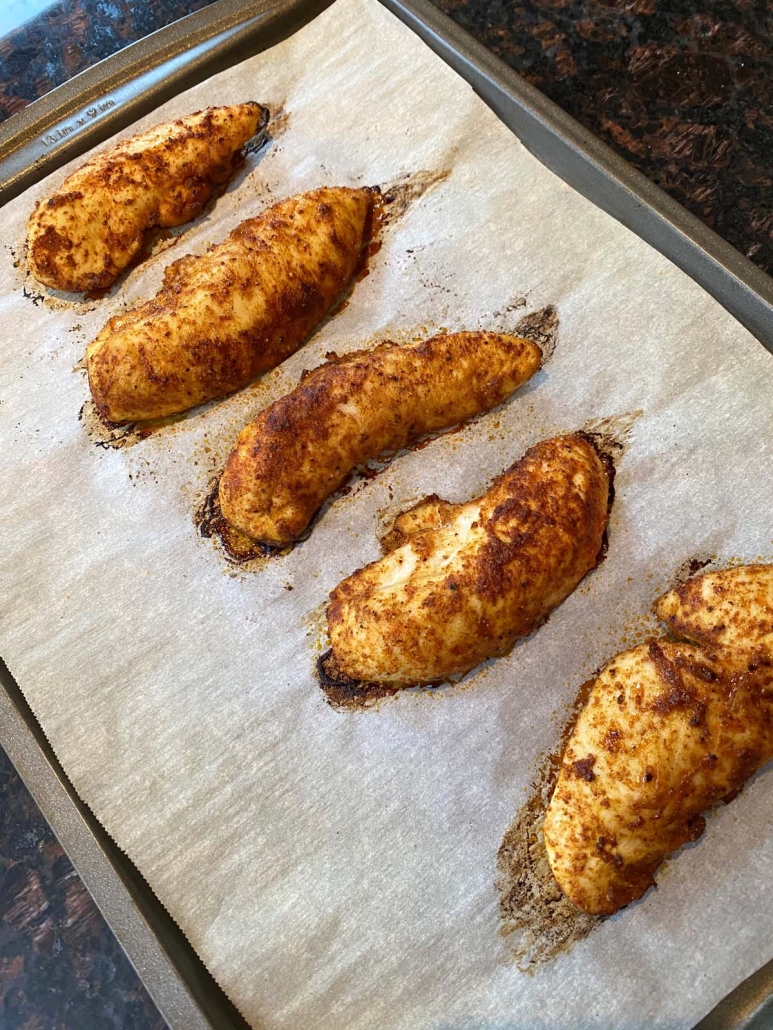 Baked Chicken Tenders No Breading on a baking sheet