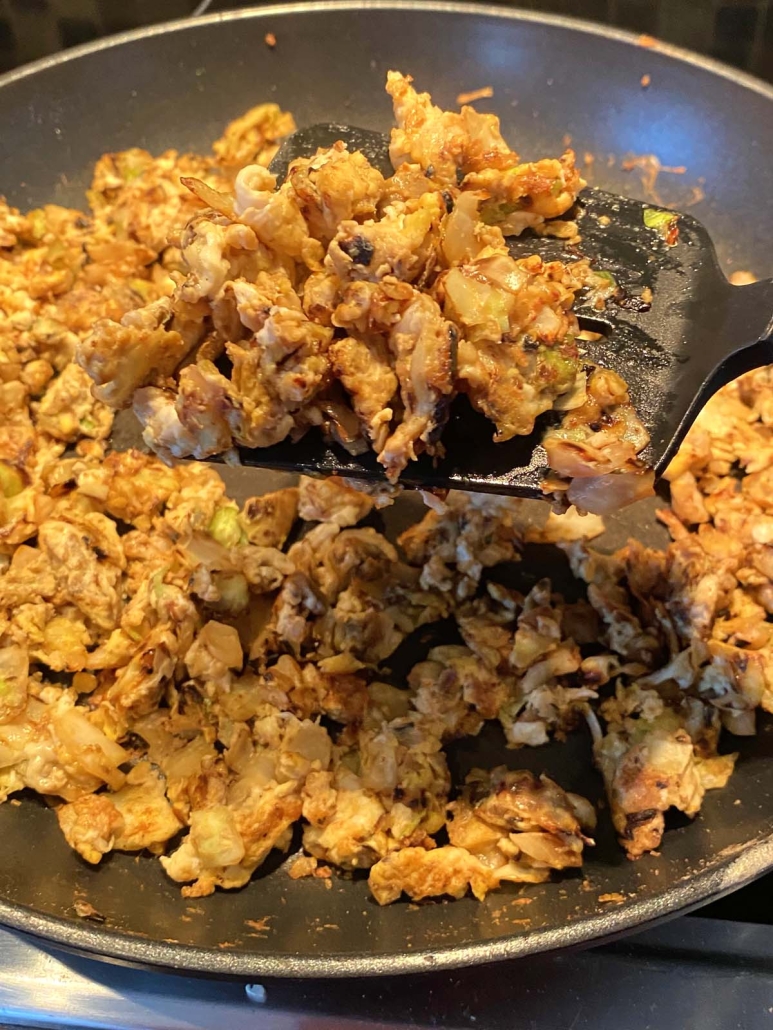 spatula mixing up Cabbage And Eggs in a skillet