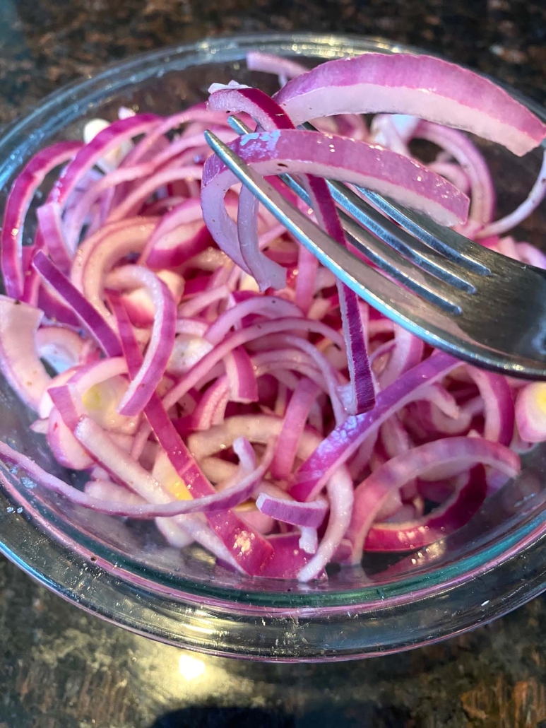 fork holding slice of pickled red onion