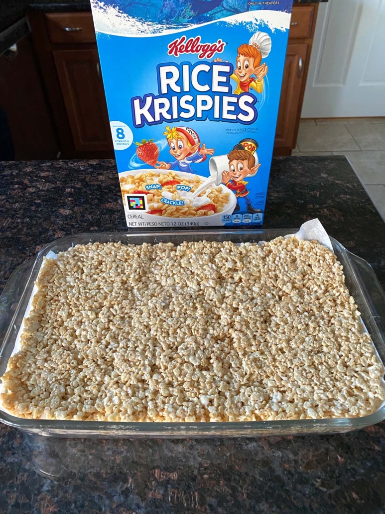 Microwave Rice Krispie Treats in a pan in front of cereal box