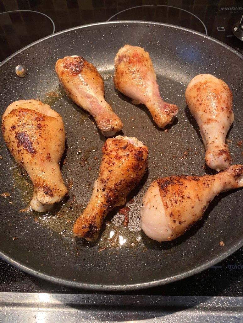 seasoned chicken drumsticks in a skillet