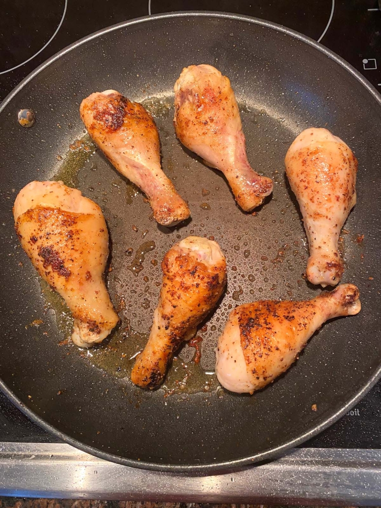 drumsticks cooking in a skillet