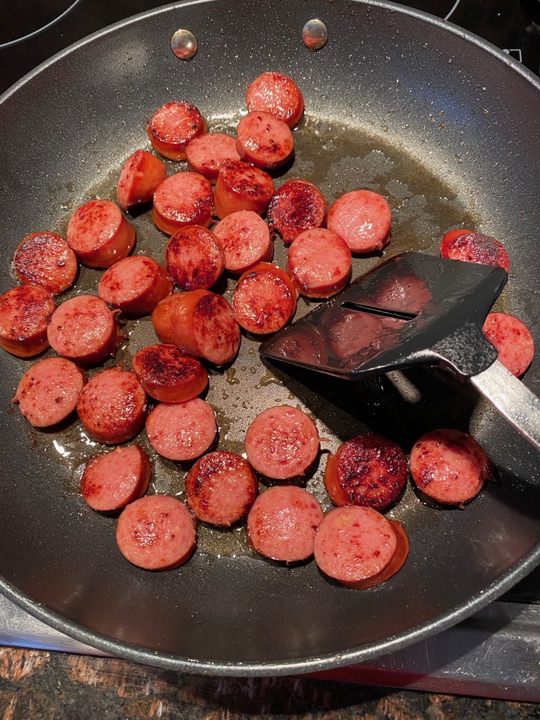kielbasa being cooked in a skillet